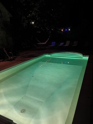 A rectangular swimming pool with a smooth surface and a drain in the center.