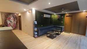 Un salon moderne avec un canapé bleu, une table basse et une horloge murale.