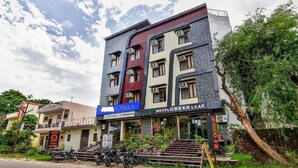 Un hôtel à plusieurs étages, avec une enseigne indiquant « HÔTELS » et « HOTEL GREEN LEAF ».