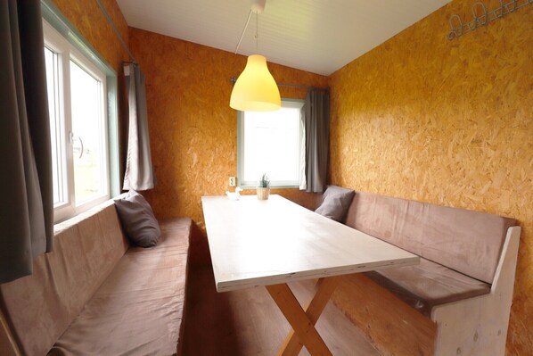 A room with a wooden wall, a white table, and two benches.