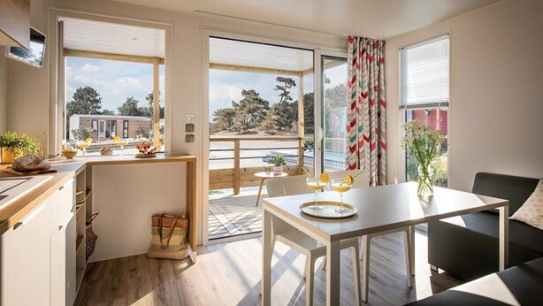 Una cocina moderna con comedor, ventanas amplias y vistas al exterior.