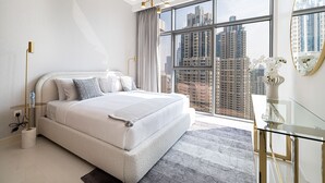 A modern bedroom with a large bed, a glass desk, and a city view through large windows. - 3Br + Maid Close To Burj Khalifa Dubai Mall (Dubai)