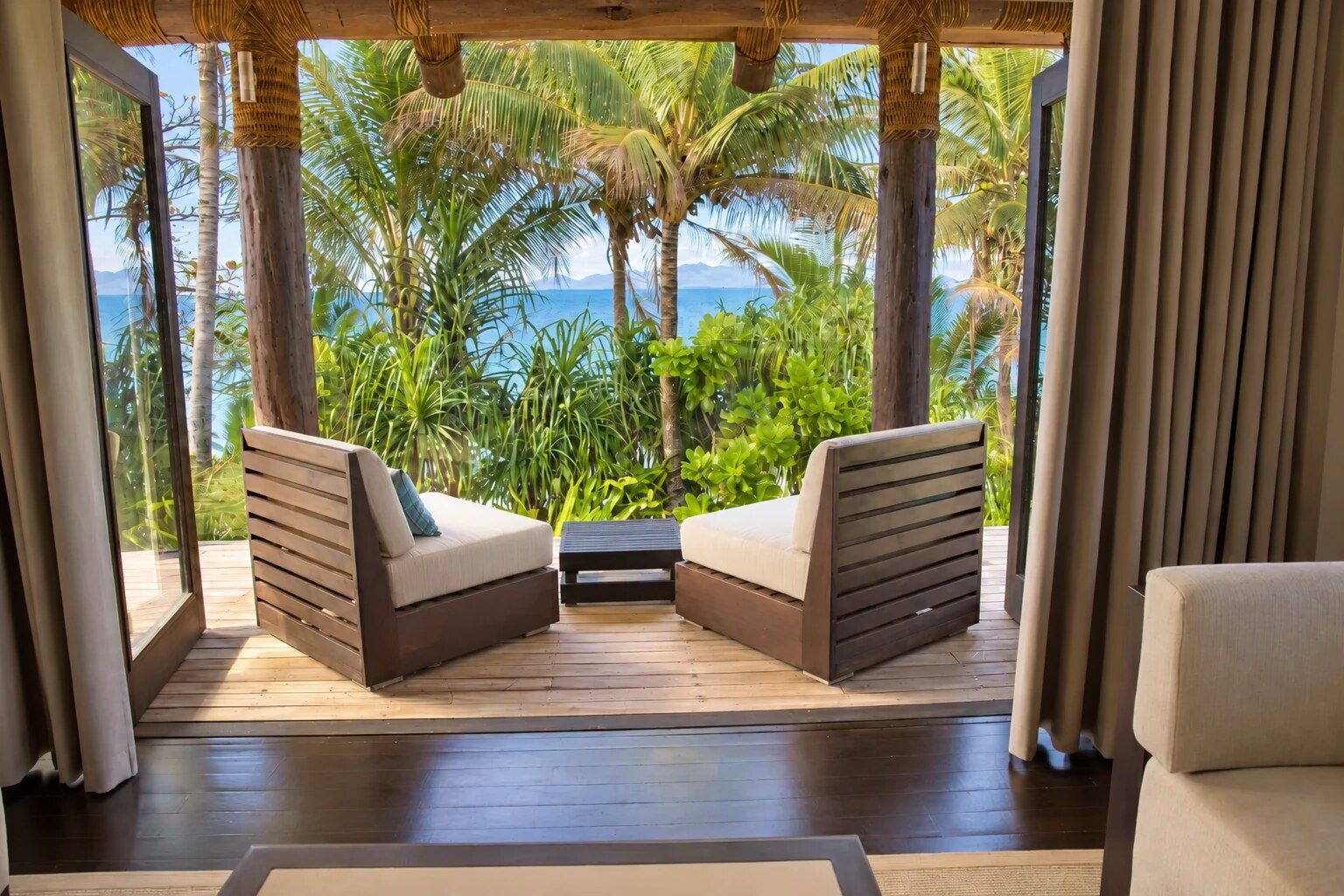 Ein Zimmer mit Meerblick, ausgestattet mit zwei Sofas und einem Holzboden.