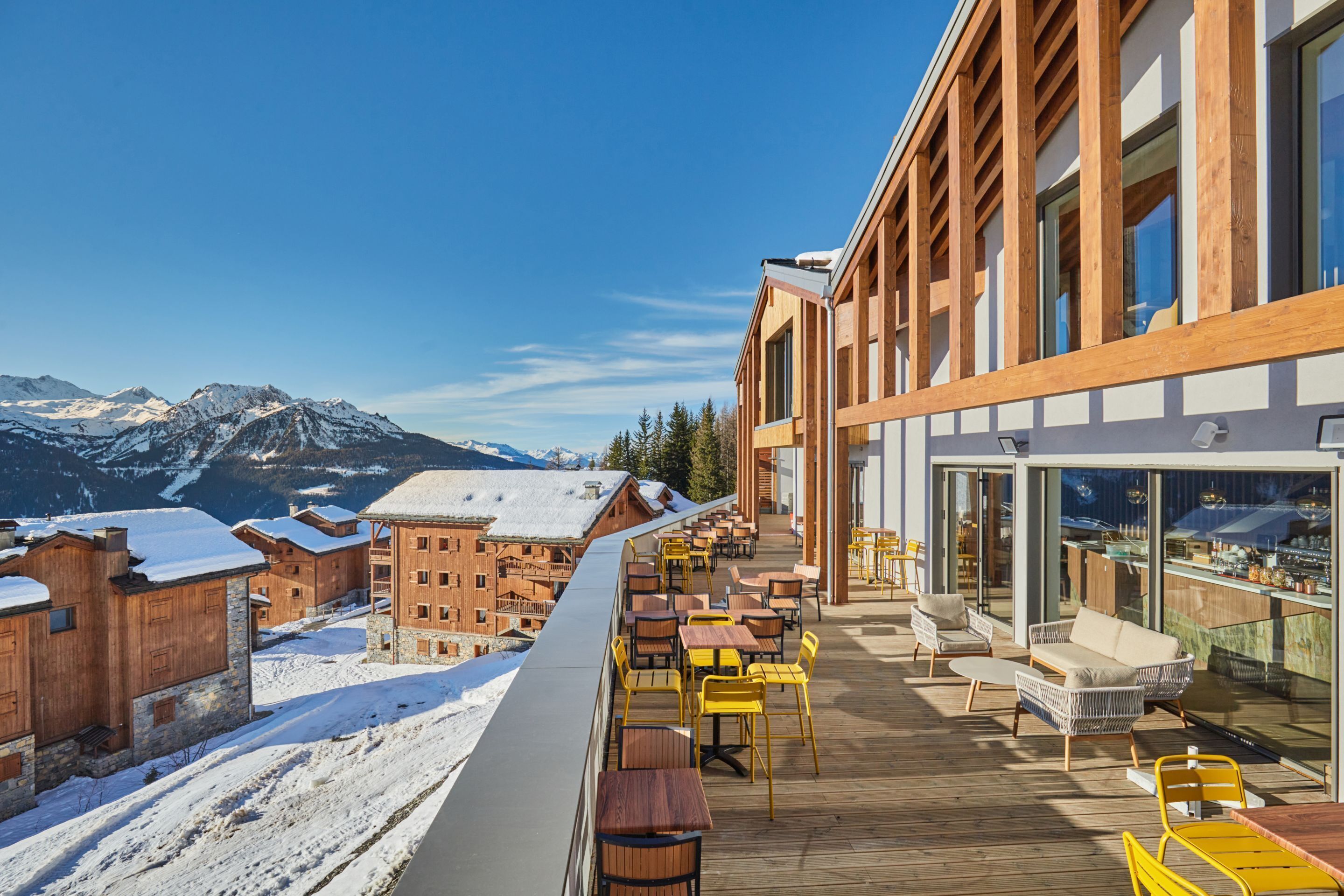 A wooden deck with outdoor seating and a mountain view.