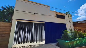 A modern building with a large garage door, a wooden deck, and a green planter. - Pacaya Samiria Experience  (Iquitos)