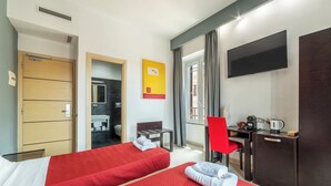 A hotel room with two beds, a desk, a chair, a TV, and a wardrobe.