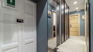 A hallway with a white door marked "Uscita di Sicurezza" (Emergency Exit), a wooden door, and a staircase leading to another room. - S. Marco Guesthouse (Rome)