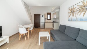 Un appartement moderne comprenant un coin repas, une cuisine et un salon.
