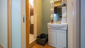 A small bathroom with a sink, mirror, and storage cabinet. - Stay Maison Hida Takayama (Takayama)