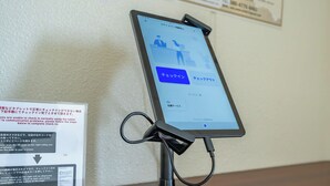 A tablet on a stand displaying a check-in interface with QR code scanning instructions. - Stay Maison Hida Takayama (Takayama)