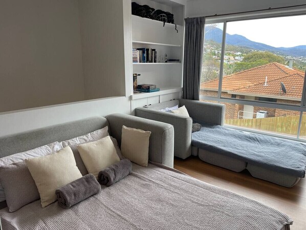 Una sala de estar moderna con un sofá, una mesita y una estantería.