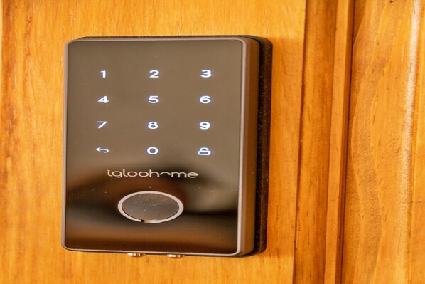 A modern, sleek, black digital keypad lock on a wooden door. - Apartment in Brighton near the Beach (Brighton)