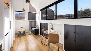 Une cuisine moderne avec un coin repas, de grandes fenêtres et une vue sur le paysage urbain.