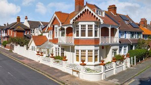 A Victorian-style house with a bay window, multiple chimneys, and a white picket fence. - Apartment in Brighton near Brighton Beach (Brighton)
