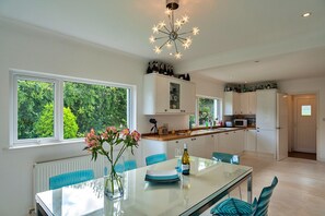Enjoy meals in the kitchen with a central island, microwave and oven, and a large window offering a view of lush greenery.