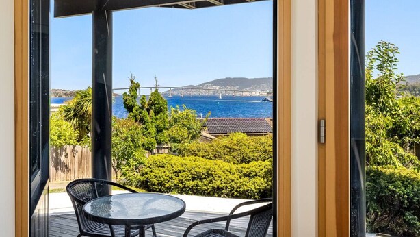 Un balcon avec vue sur la mer, une table et des chaises.
