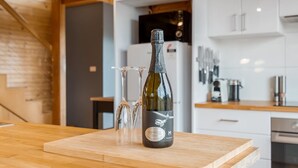Une bouteille de vin sur un comptoir en bois, avec deux verres.