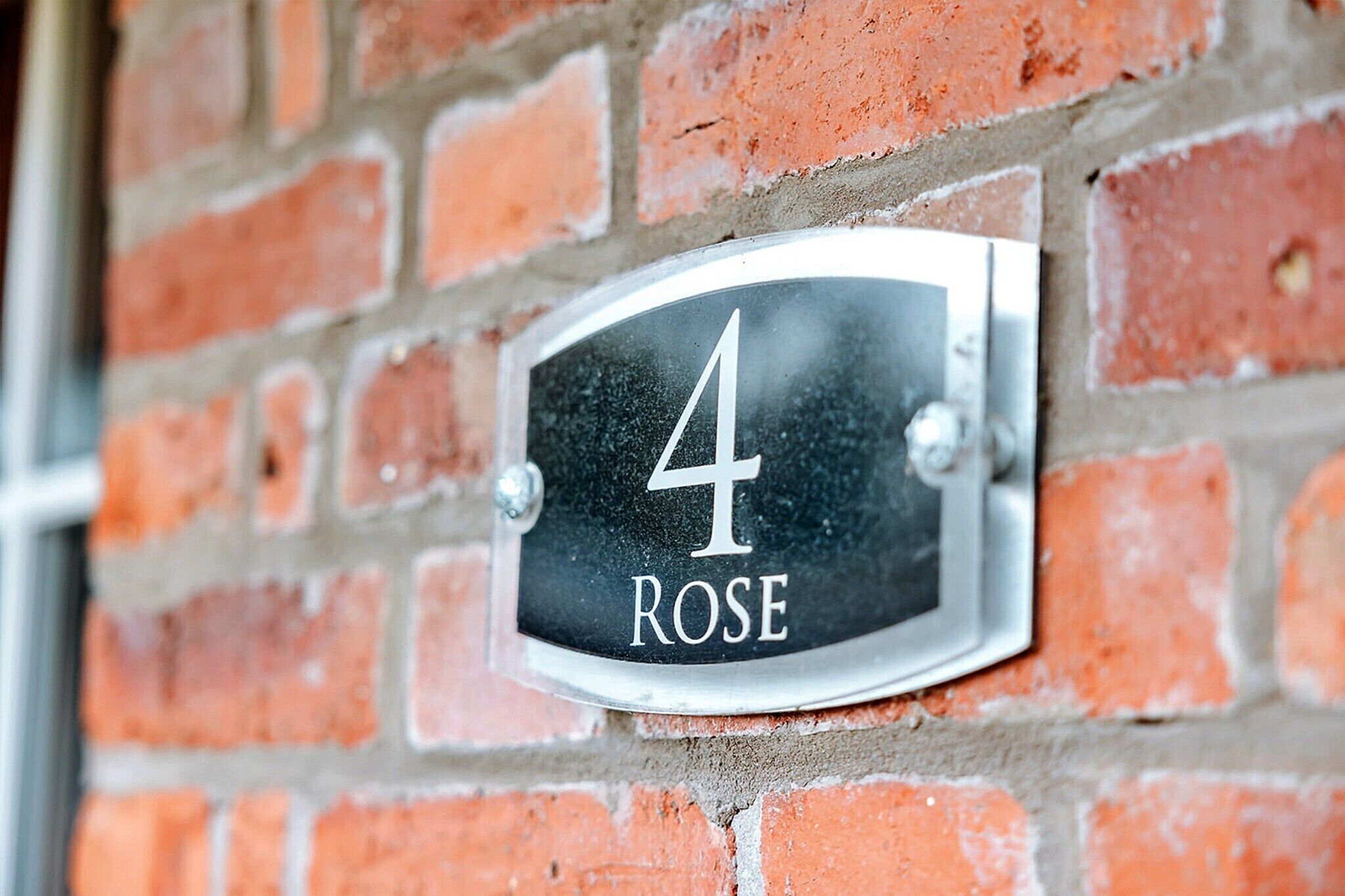 Una placa con el número de la casa en una pared de ladrillo.