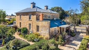 A stone house with a swimming pool, surrounded by lush greenery. - Bellevue House Historic Luxury (Richmond)