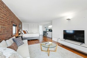 Um apartamento moderno com sala de estar, área de jantar, cozinha e um quarto.