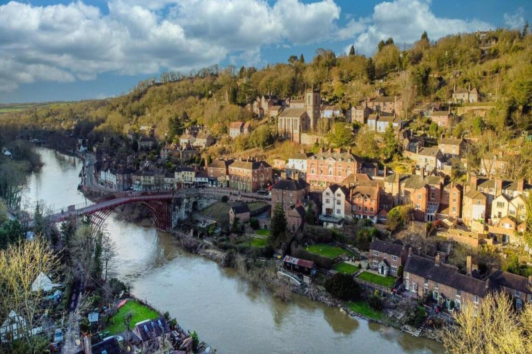 A riverside town with historic buildings, a bridge, and a church.