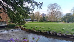 A park with a pond, a bridge, and a building with a dome in the background. - Barn in Peak District near Buxton (Buxton)