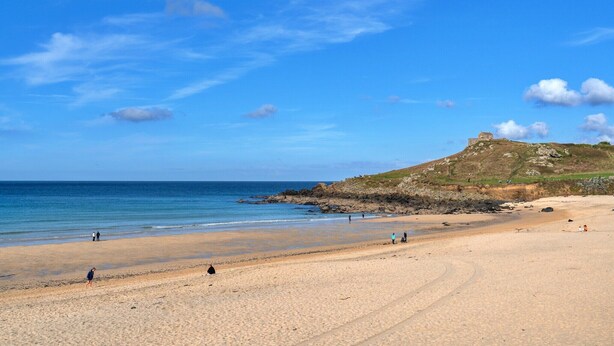 A sandy beach with a clear sky, rocky outcrops, and a hill in the background. - Apartment in St Ives near Porthminster Beach (St Ives)