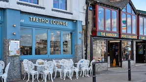 A building with a blue facade labeled "TRETHO LOUNGE" and adjacent establishments including "THE HARBOUR" and "POOL & BILLIARDS". - Apartment in St Ives near Porthminster Beach (St Ives)