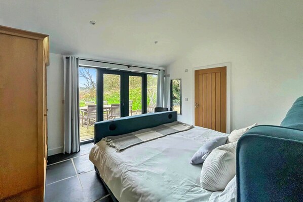 A bedroom with a bed, a window, and a door.
