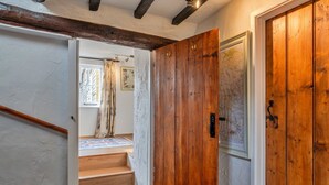 Une porte en bois ornée d’une carte, un escalier et une fenêtre avec des rideaux.