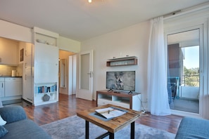 Um apartamento moderno com sala de estar, cozinha e varanda.