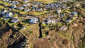 Vista aérea de uma área residencial com casas, ruas e uma pequena massa de água.