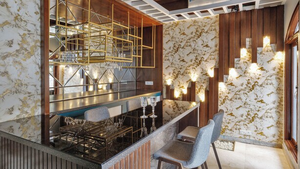 A modern kitchen with a marble backsplash, a built-in bar area, and a seating area with chairs.