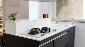 A modern kitchen with a central island, a built-in stove, and a window above the sink.