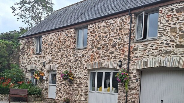 A stone building with a gravel driveway, a bench, and flower boxes. - Pet-friendly cottage in Slapton, No Deposit (Slapton)