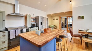 A modern kitchen with a wooden island, stainless steel appliances, and a large window. - Chalet in Summerbridge near Bank Woods (Summerbridge)