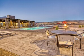 A poolside area with lounge chairs, a table, and a fire pit. - Verde Ranch RV Resort (Camp Verde)