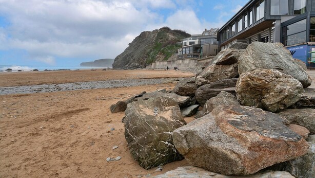 A coastal building with a modern design, large windows, and a view of the beach and ocean. - Apartment in Watergate Bay with Sea Views (Watergate Bay)