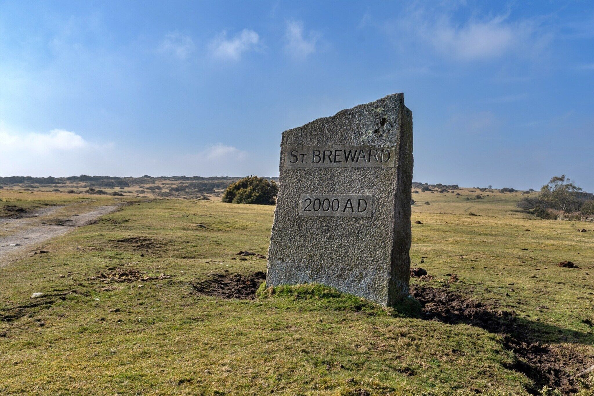 A stone monument with the inscription "St. Breward 2000 AD" in a grassy field.