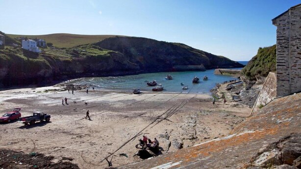 A coastal area with a sandy beach, boats, and a stone building. - Cottage in Cornwall near Bodmin Moor (St Breward)