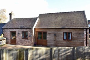 Un bâtiment à deux étages, doté d’une façade en briques et d’un revêtement en bois.