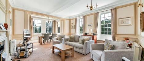 A spacious living room with a fireplace, a wooden coffee table, and a sofa set.