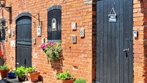A brick building with two black doors, potted plants, and a sign reading "The Hayloft". - Barn in Lincolnshire near Historic Newark (Newark)
