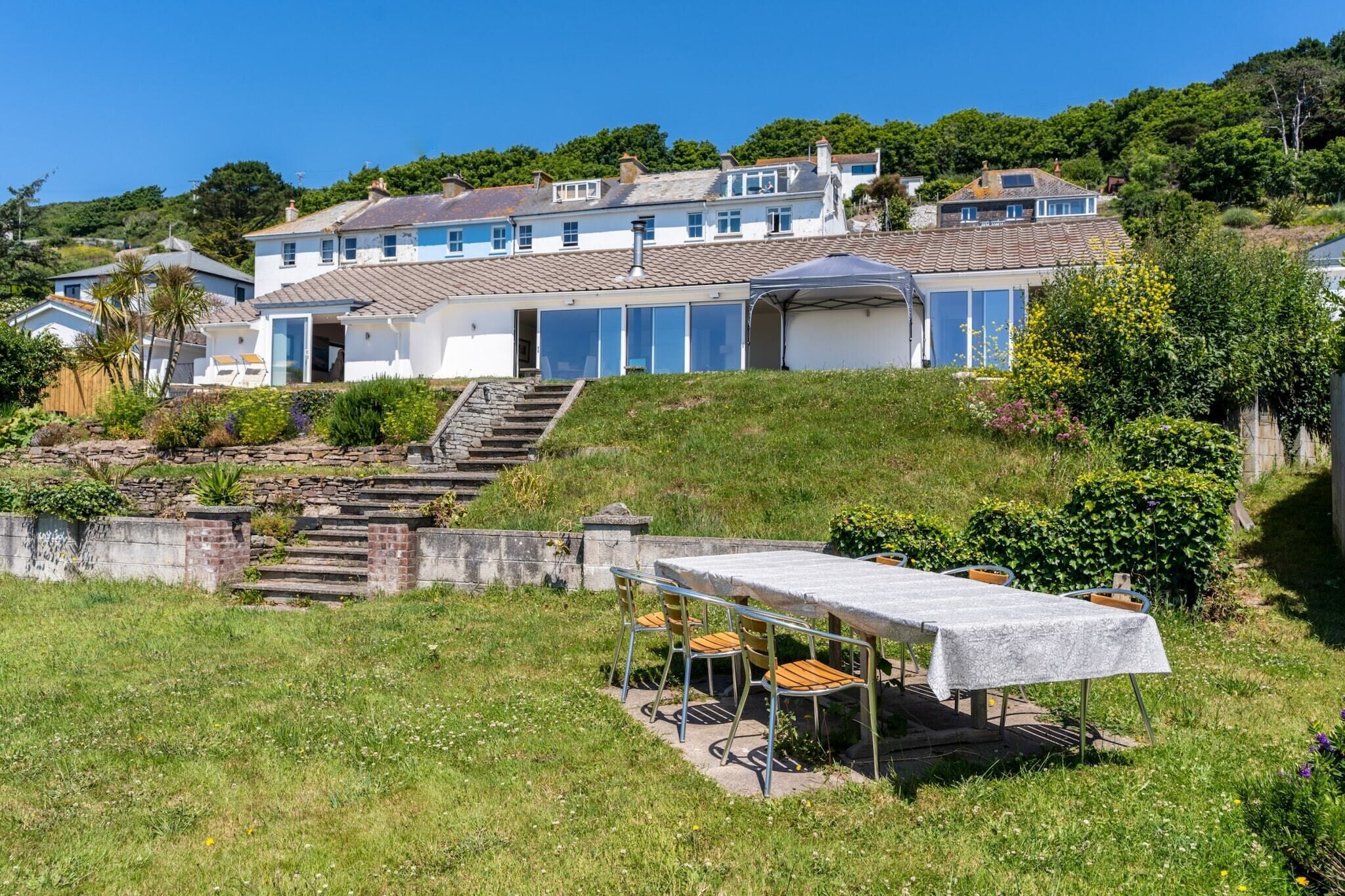 A large house with a covered patio and a staircase leading up to the entrance.