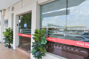 A hotel entrance with a glass door, a sign indicating it's open, and a red banner with the hotel's name. - Hotel O Cozy Fox Hotel (Petaling Jaya)