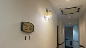 A hallway with a sign indicating room numbers 203-221 and 233-217. - Hotel O Cozy Fox Hotel (Petaling Jaya)