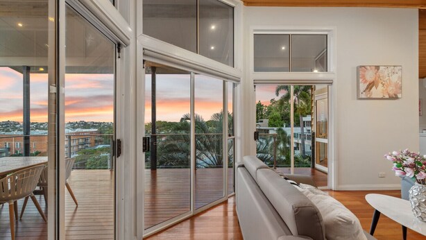 Un interior moderno con balcón, suelo de madera y sofá.