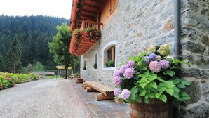 A stone building with wooden balconies and flower boxes. - Apartment in a chalet nestled in the forest, with sauna and private forest (Canal San Bovo)