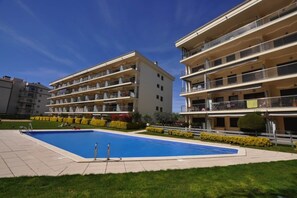 A residential building with a swimming pool, balconies, and a well-maintained lawn. - Apartment in Roses near Salatar Beach (Rosas / Roses)