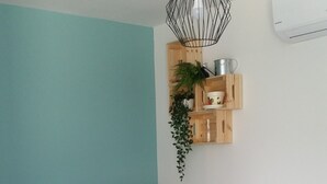 Ein modernes Wohnzimmer mit Fernseher, Sofa und einem kleinen Esstisch.